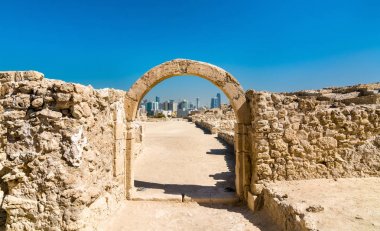 Manama manzarası ile eski arch Bahreyn Fort adlı. UNESCO Dünya Miras Listesi