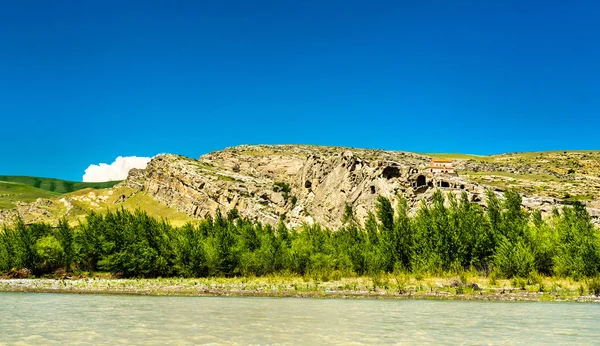 Uplistsikhe en una orilla del río Kura, una antigua ciudad excavada en roca en Georgia — Foto de Stock