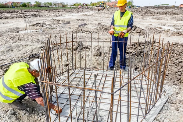 Lavoratori edili barra vincolante per rafforzare colonna di cemento armato — Foto Stock