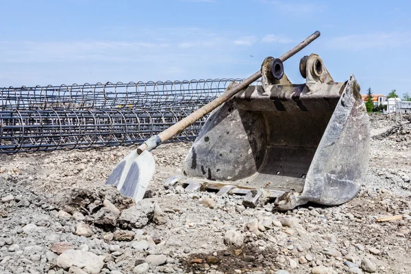 Cubo y pala de excavadora frente a esqueleto reforzando s —  Fotos de Stock