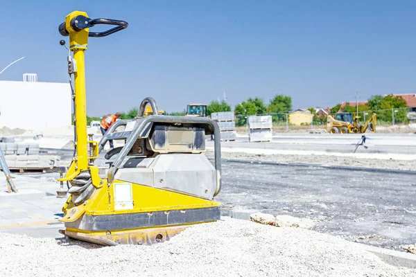 Máquina compactadora de placa de vibración está de pie en el sitio de construcción — Foto de Stock