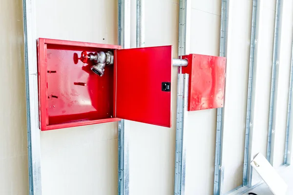 Scatola rossa con idrante è costruito in una parete in gesso non finito — Foto Stock