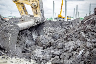 Ekskavatör'ın aracı, kova, ağız, arkasında bulutlu gökyüzü