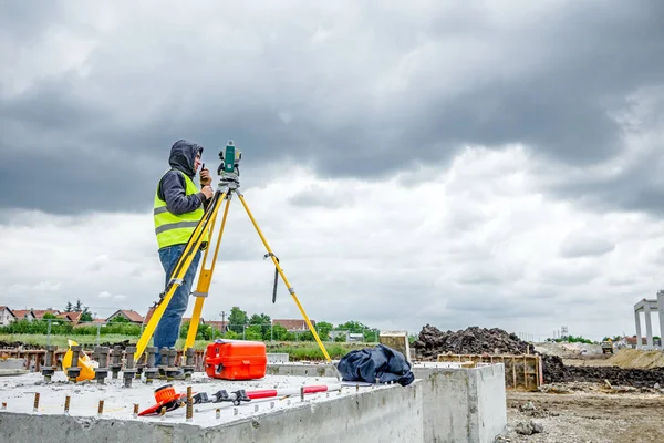 Geodesist está trabalhando com estação total em um canteiro de obras. Civi. — Fotografia de Stock