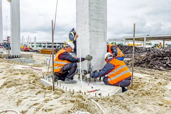 Vista no canteiro de obras até que os trabalhadores estejam montando pilar de concreto — Fotografia de Stock