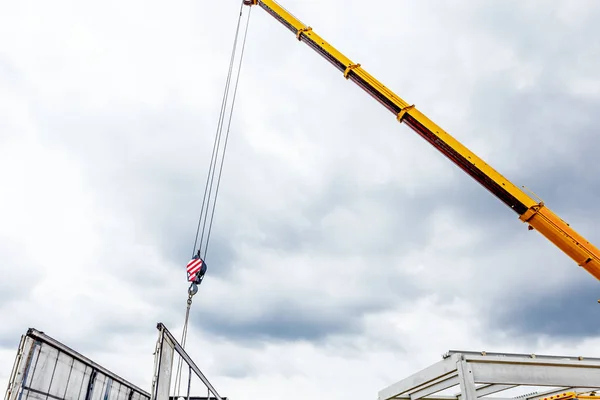 Żuraw samojezdny jest rozładunek betonowych belek z przyczepy ciężarówki — Zdjęcie stockowe