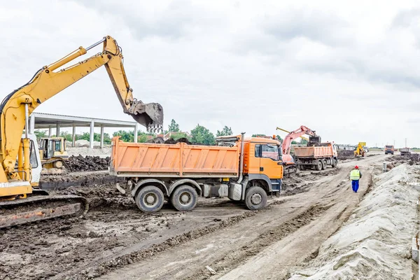 Excavatrice charge un camion sur le chantier — Photo