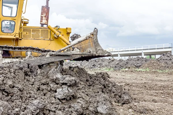 Máquina de construção de terraplenagem pesada está movendo terra em buildin — Fotografia de Stock