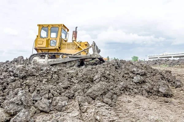 Zware earthmover bouw machine beweegt aarde op de ingebouwde — Stockfoto