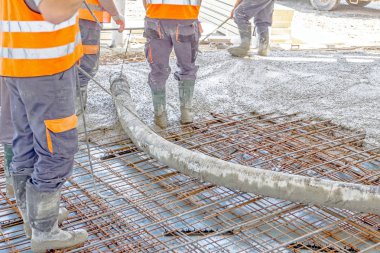 İşçiler da yayılıyor beton büyük güçlendirilmiş yere üzerinde 