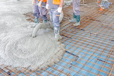 İşçiler da yayılıyor beton büyük güçlendirilmiş yere üzerinde 