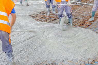 İşçiler da yayılıyor beton büyük güçlendirilmiş yere üzerinde 