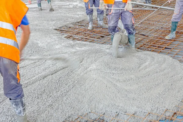 İşçiler da yayılıyor beton büyük güçlendirilmiş yere üzerinde 