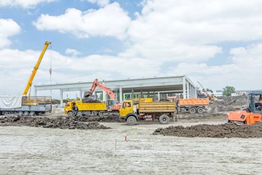 Şantiye makineleri ile bitmemiş modern edif göster