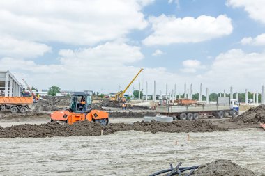 Şantiye makineleri ile bitmemiş modern edif göster