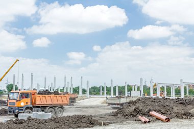 Şantiye makineleri ile bitmemiş modern edif göster