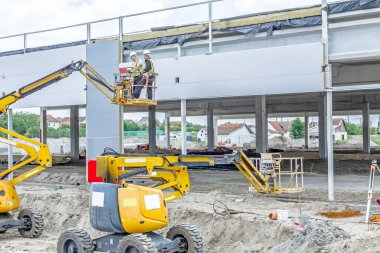 Takım inşaat işçileri kompozit panel duvarlar yüklüyor