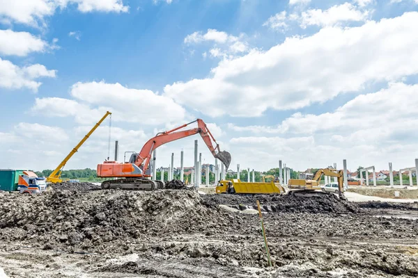 Bagger belädt Lastwagen auf Baustelle — Stockfoto