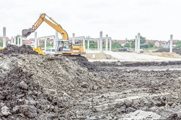 Excavadora está cargando un camión en el sitio de construcción — Foto de Stock