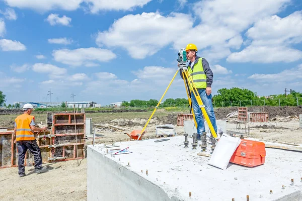 Geodesist está trabalhando com estação total em um canteiro de obras. Civi. — Fotografia de Stock