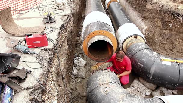 El trabajador está limpiando el tubo de la suciedad con una máquina de pulir — Vídeo de stock