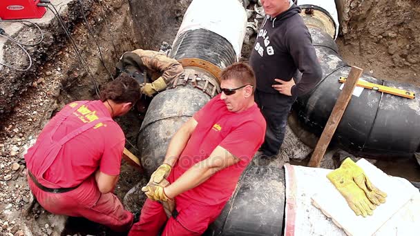 Équipe de travailleurs dans la tranchée travaillant dur pour assembler un nouveau pipeline — Video
