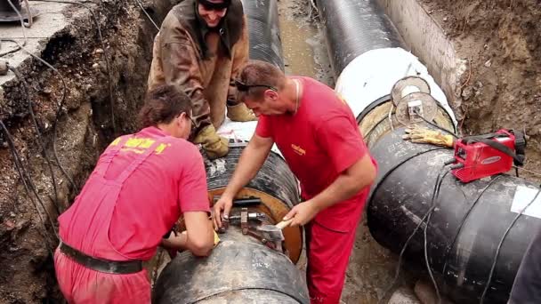 El trabajador está ajustando la herramienta colocada en el tubo para soldar dos tubos — Vídeo de stock