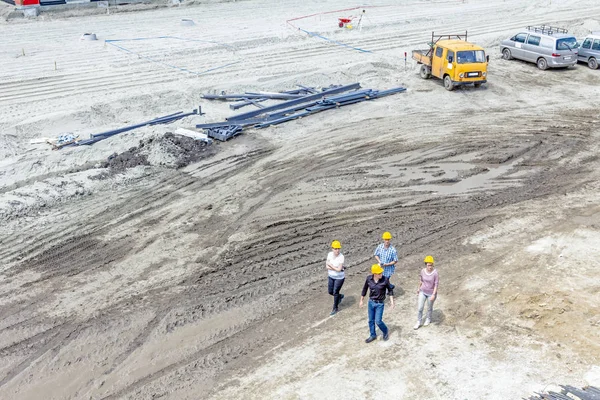 Equipo de gerentes en cascos está caminando en el sitio de construcción. Fuera. — Foto de Stock