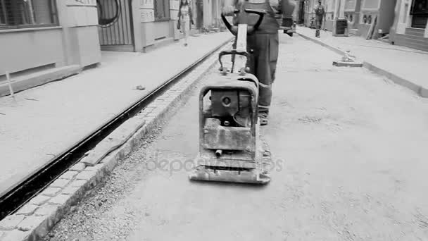Vibrating machine is compacting soil at the construction site. — Stock Video