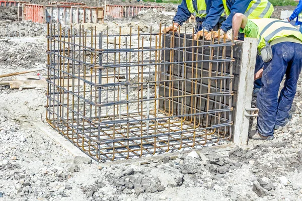 Рабочие собирают пресс-форму с армирующей сеткой для бетона — стоковое фото