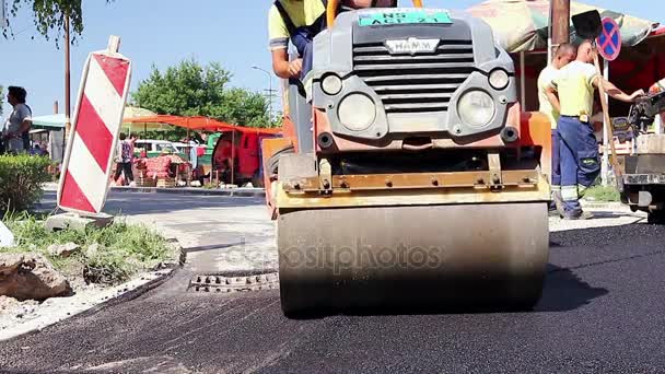 Steamroller are spreading, flatting hot asphalt. — Stock Video