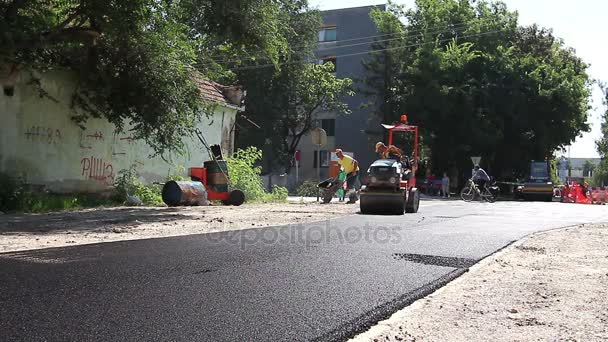 Twee steamrollers zijn verspreiden, flatting warm asfalt. — Stockvideo