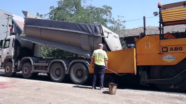 Continuidad en el proceso de esparcimiento de asfalto con maquinaria para la construcción de carreteras — Vídeos de Stock