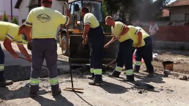工人正在用铁锹去除多余的停机坪，沥青. — 图库视频影像