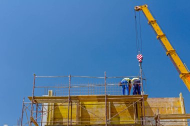 Vinç riggers ile çalışma, işçilerin derleme büyük kalıp Betonlama için gerekli.