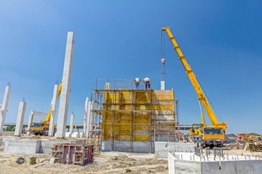 Vinç riggers ile çalışma, işçilerin derleme büyük kalıp Betonlama için gerekli.