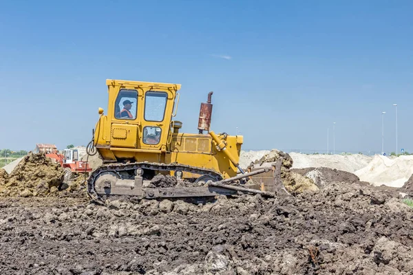 Máquina de construção de terraplenagem pesada está movendo terra no local de construção . — Fotografia de Stock