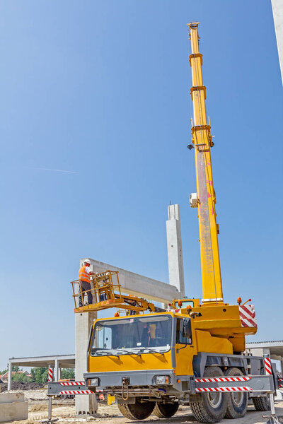 Mobile crane is carry concrete joist to assembly huge hall