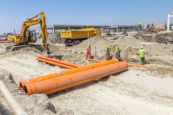 Het plaatsen van nieuwe kunststof buizen in de grond — Stockfoto