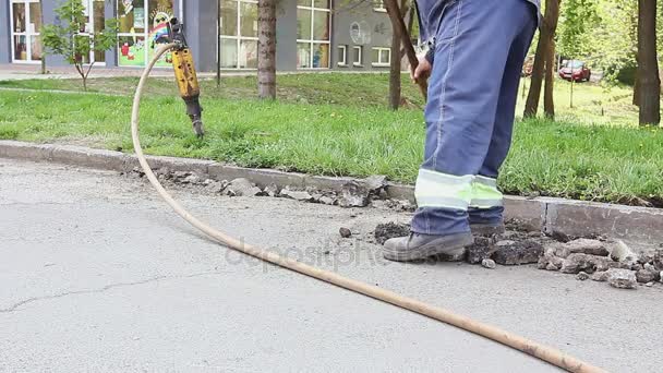 Arbeiter sammelt mit Schaufel kaputten Asphalt ein — Stockvideo