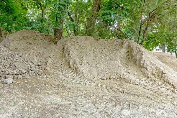 Pilhas de terra na floresta decídua, parque, marcas de pneus — Fotografia de Stock