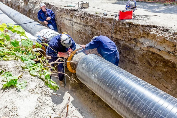 Arbetstagare ställer uppsättning frigolit värmeisolering på ny rörledning. — Stockfoto