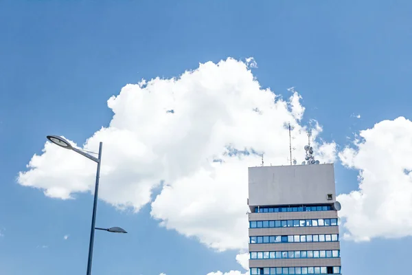 Moderno poste de luz, edificio empresarial y nube blanca —  Fotos de Stock