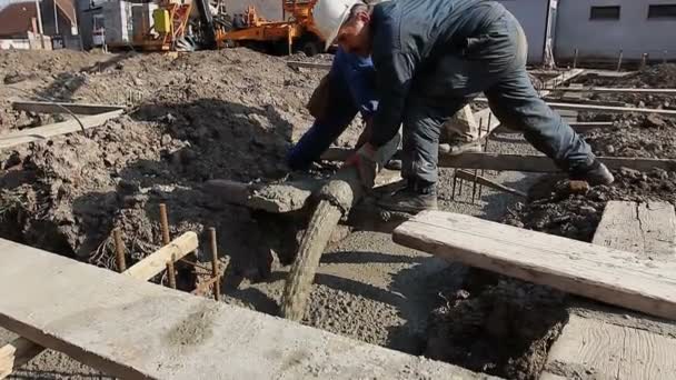 Monteurs, werknemers houden pomp slang te gieten vers beton in het opbouwen van de Stichting — Stockvideo