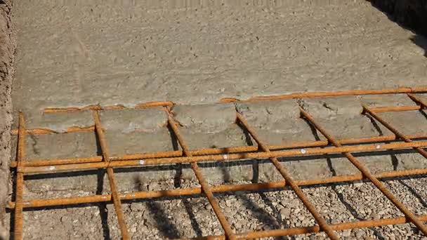 Бетон распыляется в фундаменте над армирующими стальными прутьями . — стоковое видео