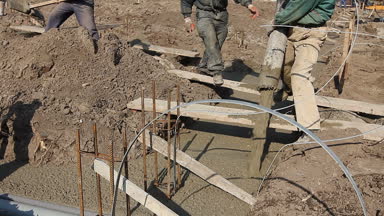 Riggers, işçi pompa hortumu yağan taze beton için temel yapı içine tutuyorsun