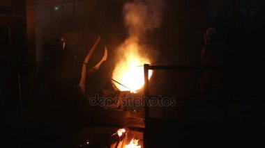 İşçiler uzun çubuklar ile yüksek fırın atölye erimiş metal pislik kaldırdığınızı