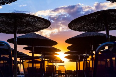 Thatched şemsiye şezlong ile görünümünü yanında siluet 