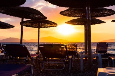 Thatched şemsiye şezlong ile görünümünü yanında siluet 