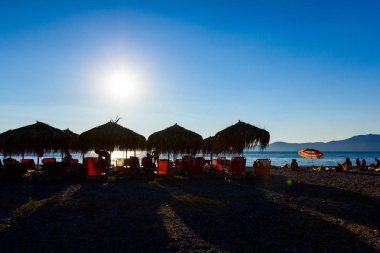 Kıyı şeridi yanındaki thatched şemsiye görünümünü siluet 